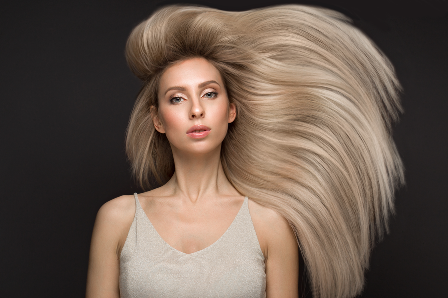 Woman with smooth, healthy blonde hair using color-safe products